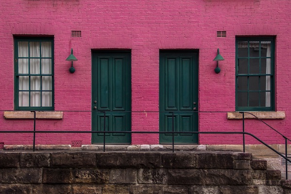 Ein pinke Hausfassade mit grünen Türen - sharing economy in der Schweiz